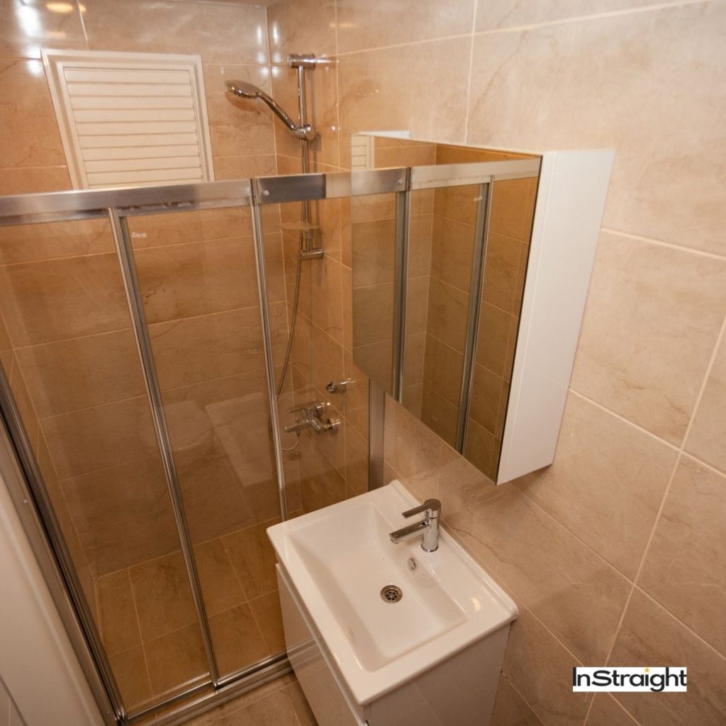 Cabinet mirror on top of white sink under title What Type of Mirror is Used in Bathrooms